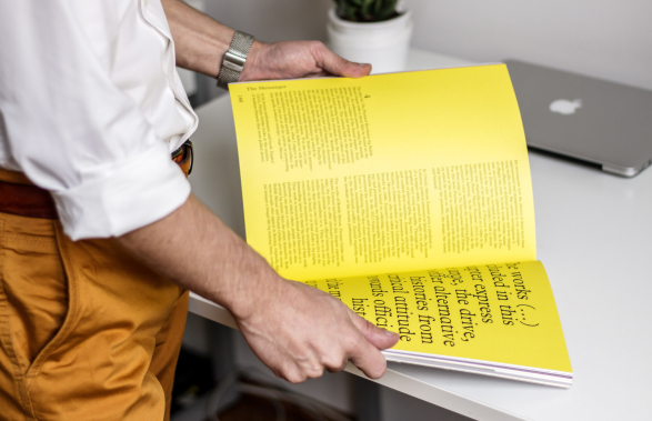 Imprimeur tenant un livre jaune illustrant notre expertise